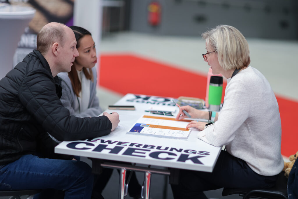 Ein Paar wird bei einem Bewerbungscheck-Stand auf der jobmesse austria betreut.