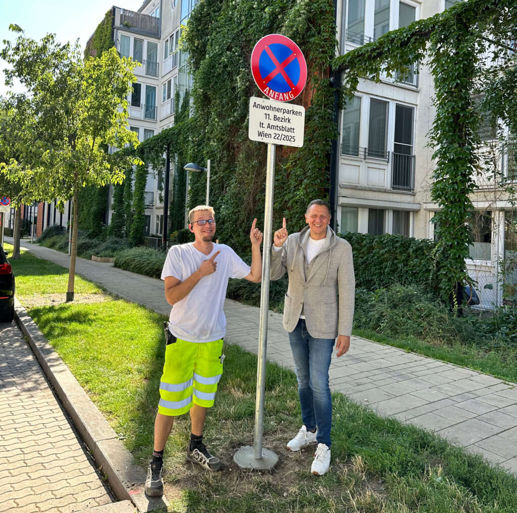 DerSimmeringer Bezirksvorsteher Thomas Steinhart mit einem Stadt Wien-Mitarbeiter vor den Hinweistafeln zum Anwohnerparken. © BV 11